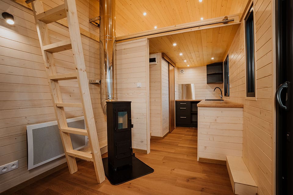 L'espace intérieur de la Tiny House Colibri avec un poêle à bois